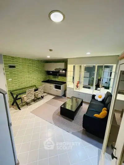 Modern living room with open kitchen, stylish decor, and cozy seating area.