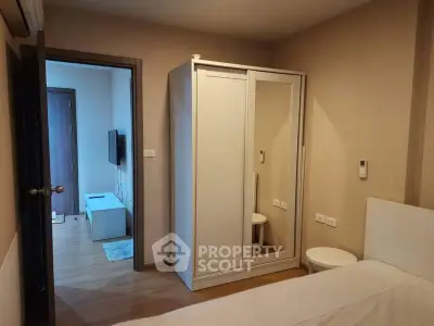 Cozy bedroom with mirrored wardrobe and view into living area