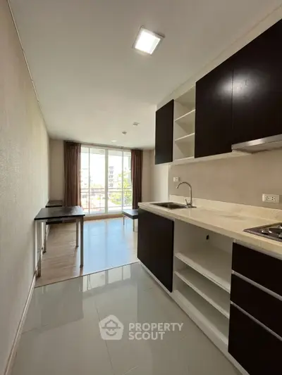 Modern open-layout kitchen with sleek cabinetry and bright living area, ideal for urban living.