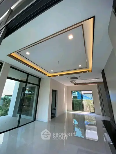 Spacious modern living room with elegant ceiling design and large windows