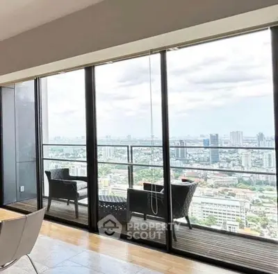 Stunning high-rise balcony with panoramic city view and modern seating area.