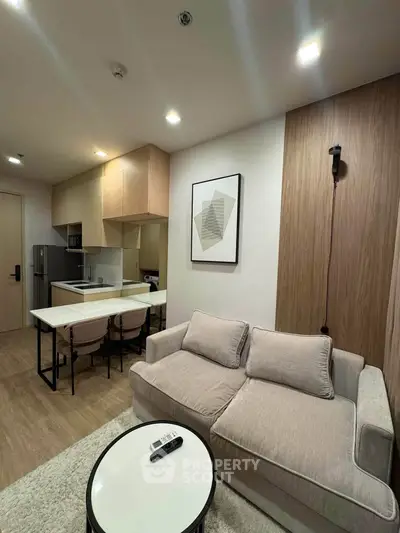 Modern living room with cozy sofa and stylish kitchen in open layout apartment.