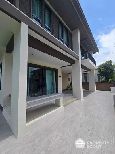 Modern two-story house with spacious patio and large windows