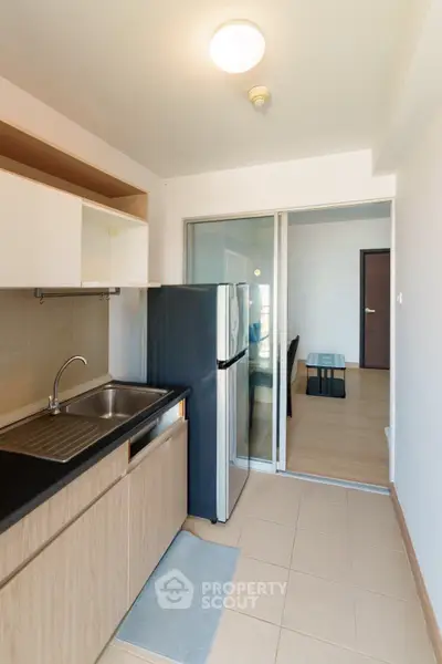 Modern kitchen with sleek design and open layout leading to a cozy living area.