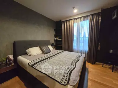 Cozy bedroom with modern decor and large window for natural light.