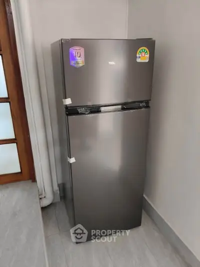 Modern kitchen with sleek stainless steel refrigerator in corner