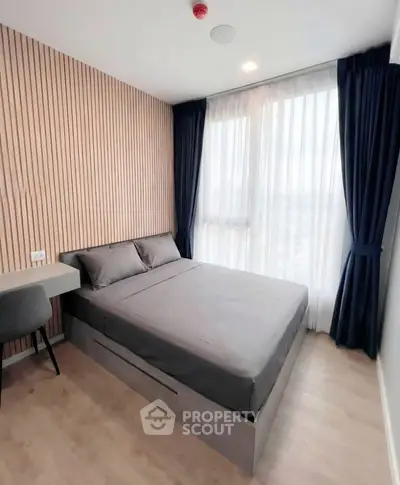 Modern bedroom with sleek design and large windows offering natural light.