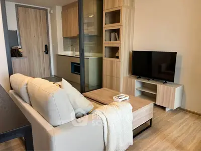 Modern living room with cozy sofa, TV, and stylish wooden furniture in open layout apartment.
