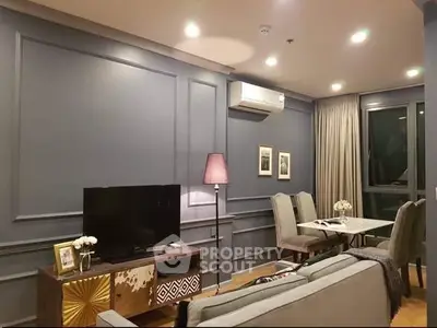 Stylish living room with modern decor and dining area, featuring elegant lighting and cozy ambiance.