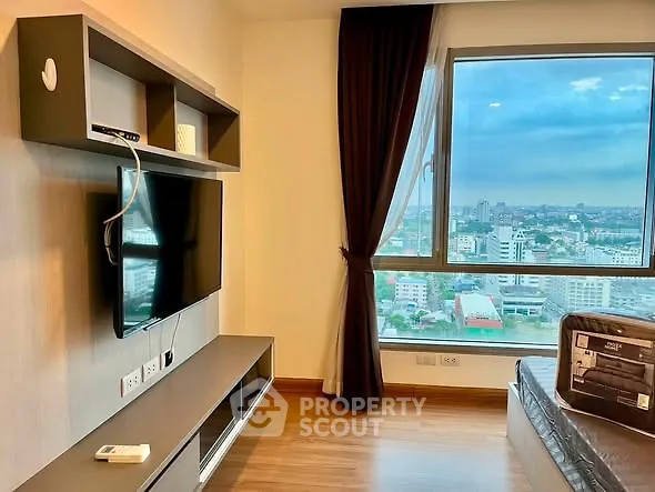 Modern living room with large window offering stunning city views, sleek TV setup, and elegant decor.