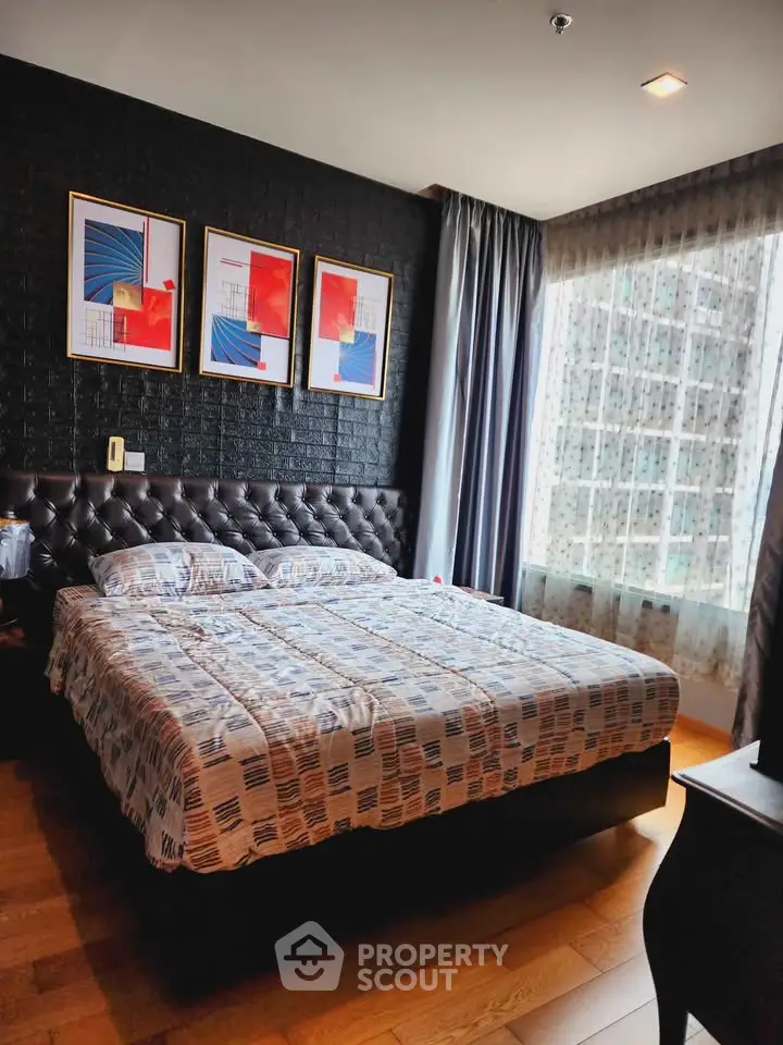 Luxurious bedroom with modern decor and large window offering city views