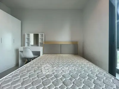 Modern minimalist bedroom with sleek furniture and ample natural light.