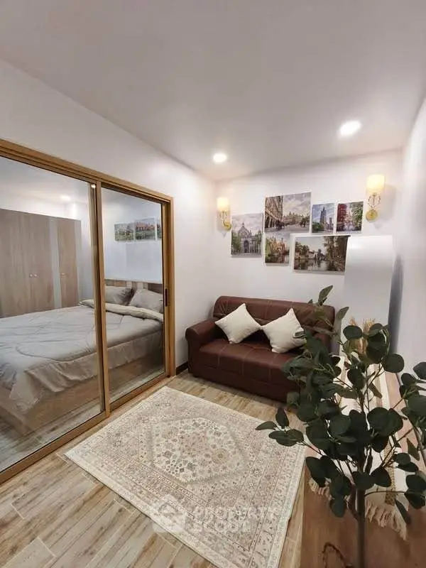 Cozy living room with elegant decor and a view into a stylish bedroom through sliding glass doors.