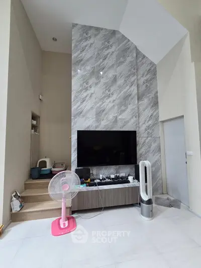 Modern living room with high ceiling and sleek TV setup