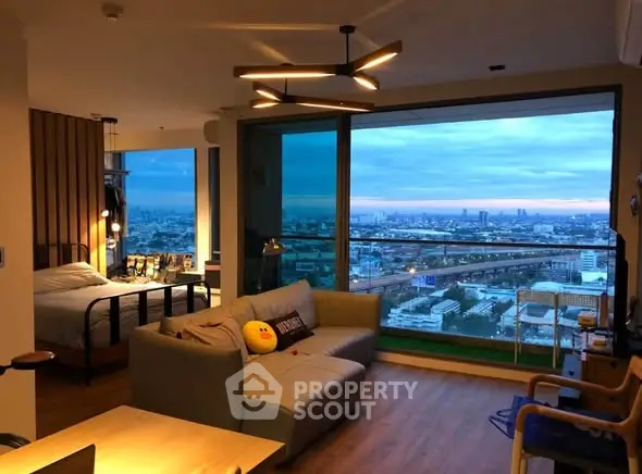 Stunning modern living room with panoramic city view and cozy bedroom corner.