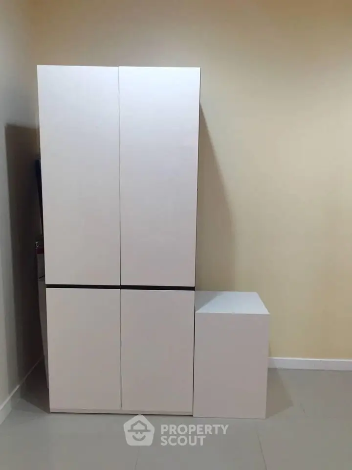 Modern minimalist white storage cabinet in a sleek interior setting.