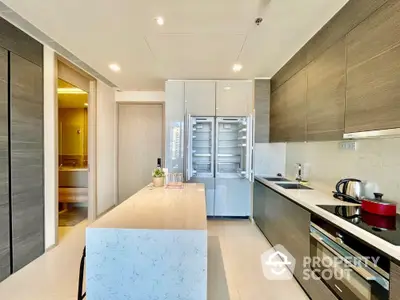 Modern kitchen with sleek design, featuring marble island and high-end appliances in luxury apartment.