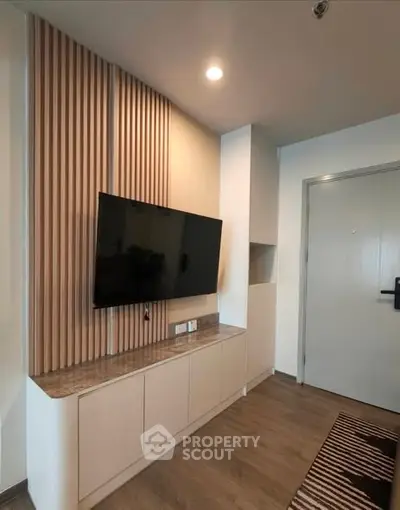 Modern living room with sleek TV setup and stylish wood paneling