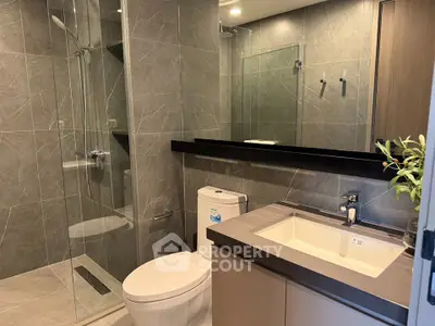Modern bathroom with sleek design, glass shower, and elegant fixtures in a luxury apartment.