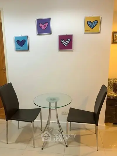 Cozy dining nook with modern glass table and stylish chairs, perfect for intimate meals.