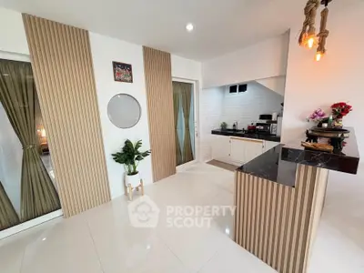 Modern kitchen with sleek design and open layout, featuring stylish lighting and contemporary decor.