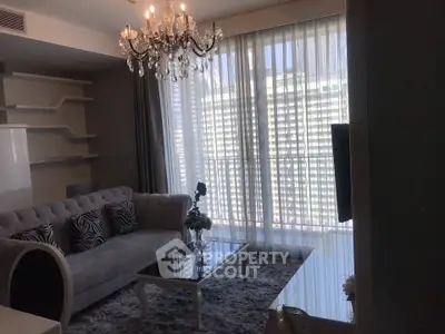Luxurious living room with elegant chandelier and plush sofa in modern apartment