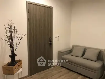 Cozy small living area with modern sofa and decorative vase, perfect for compact spaces.