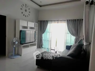 Spacious living room with modern decor and large TV, perfect for relaxation.