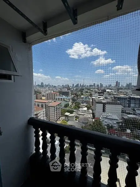 Stunning cityscape view from a high-rise balcony with protective netting.