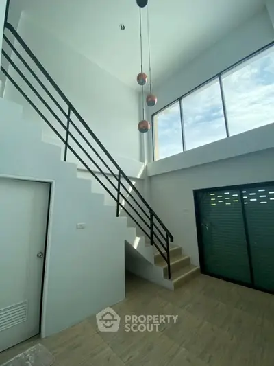 Modern duplex interior with high ceilings and large windows