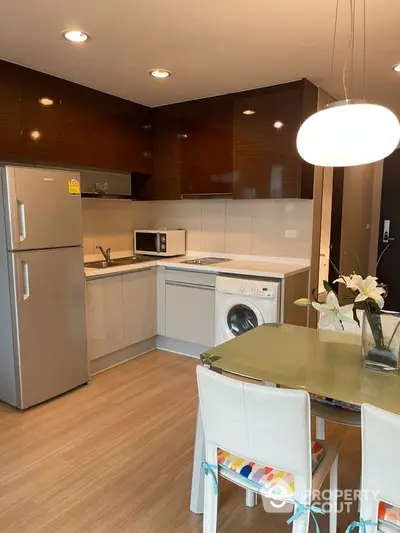 Modern kitchen with sleek appliances and dining area in stylish apartment