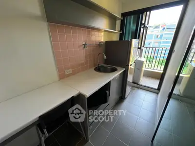 Modern compact kitchen with balcony view in urban apartment
