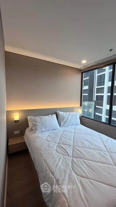 Modern bedroom with large window and cozy lighting in urban apartment