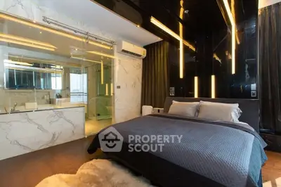 Luxurious modern bedroom with sleek black accents and glass-walled bathroom.