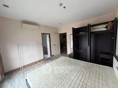 Spacious bedroom with built-in wardrobe and air conditioning in modern apartment.