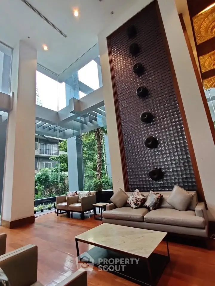 Luxurious modern lobby with high ceilings and elegant seating area in upscale building.