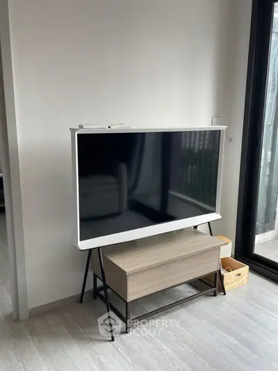 Modern living room with sleek TV stand and large window for natural light.