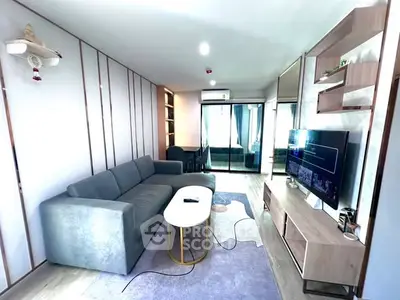 Modern living room with sleek furniture and large TV, perfect for relaxation.