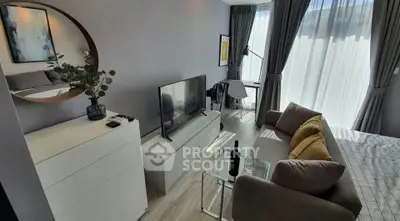 Modern living room with stylish decor, large TV, and natural light from floor-to-ceiling windows.