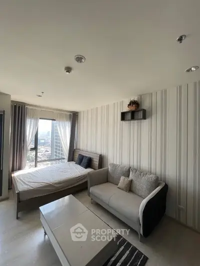 Modern bedroom with city view, stylish decor, and cozy seating area.