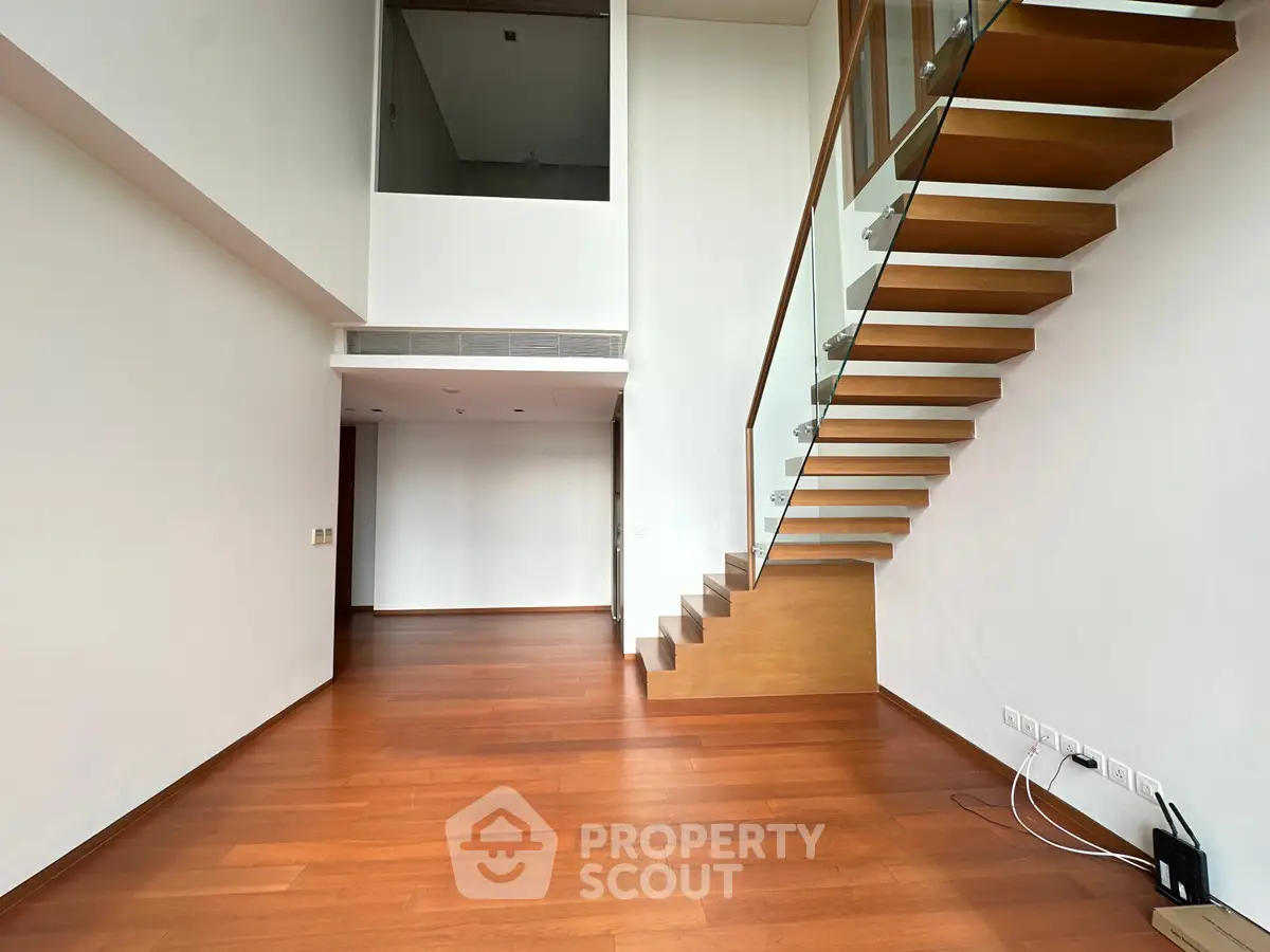 Spacious modern living room with wooden floors and stylish staircase