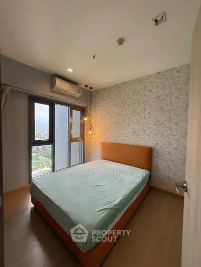 Modern bedroom with large window and stylish lighting in a high-rise apartment.