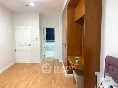 Spacious room with wooden flooring and built-in wardrobe, ideal for modern living.