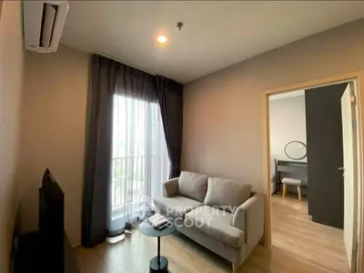 Modern living room with cozy sofa and natural light from large window in stylish apartment.