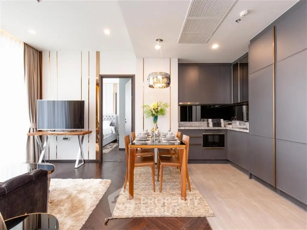 Modern open-layout living room with sleek kitchen and dining area, featuring stylish furniture and elegant decor.