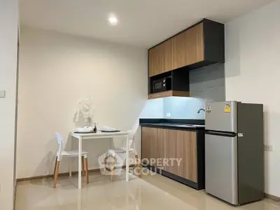 Modern kitchen with sleek cabinetry and dining area in cozy apartment