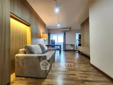 Spacious living room with modern decor and wooden flooring, perfect for relaxation.