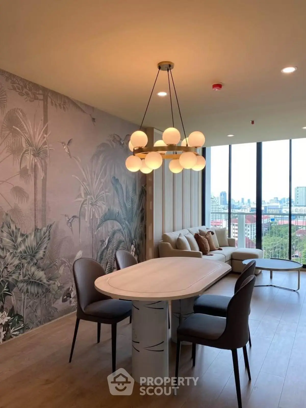 Stylish living room with modern chandelier and panoramic city view, featuring elegant dining area and cozy seating.