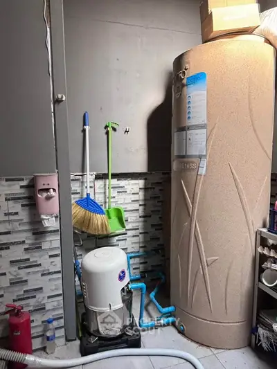 Utility room with water heater and cleaning supplies