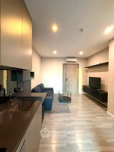 Modern living room with sleek kitchen and cozy seating area, perfect for urban living.